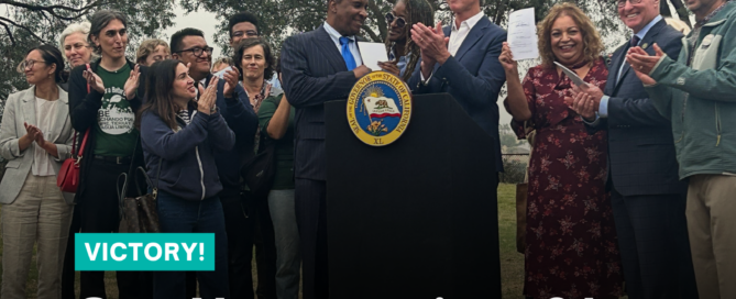 California Governor signing bills at a lectern with group of advocates around him.